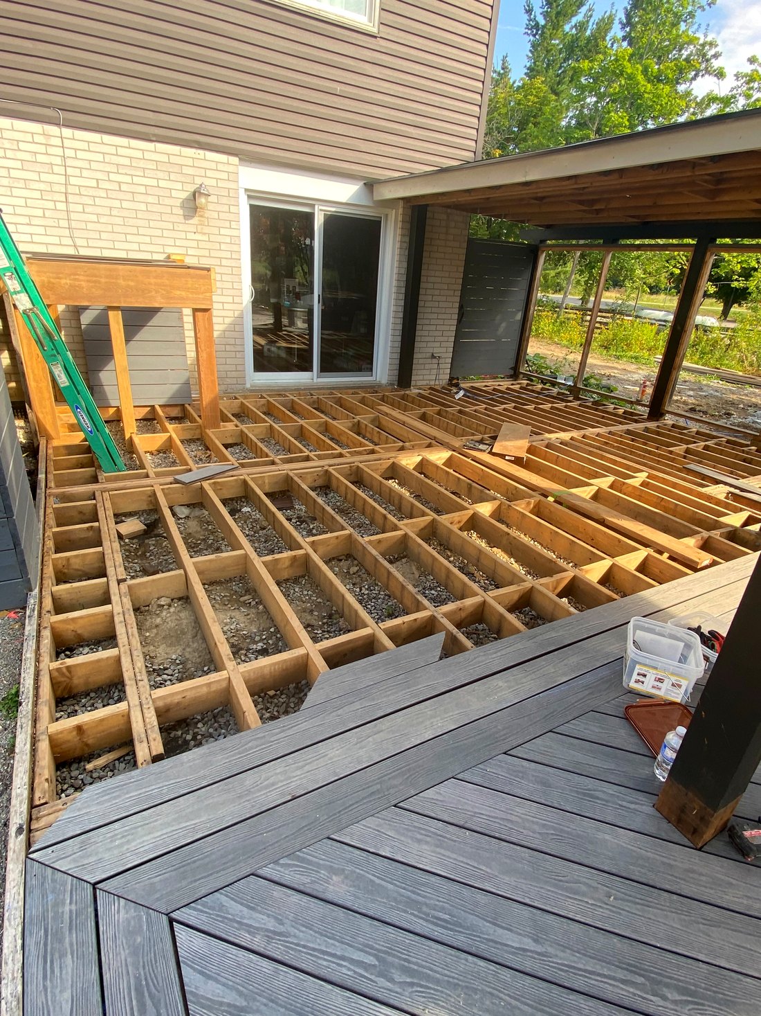 Grey composite deck boards installed over new joist framing
